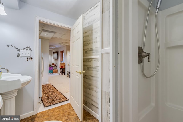 bathroom featuring a sink, tile patterned flooring, and a paneled ceiling