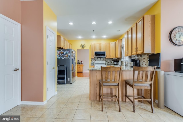 kitchen with light tile patterned floors, recessed lighting, a peninsula, appliances with stainless steel finishes, and decorative backsplash