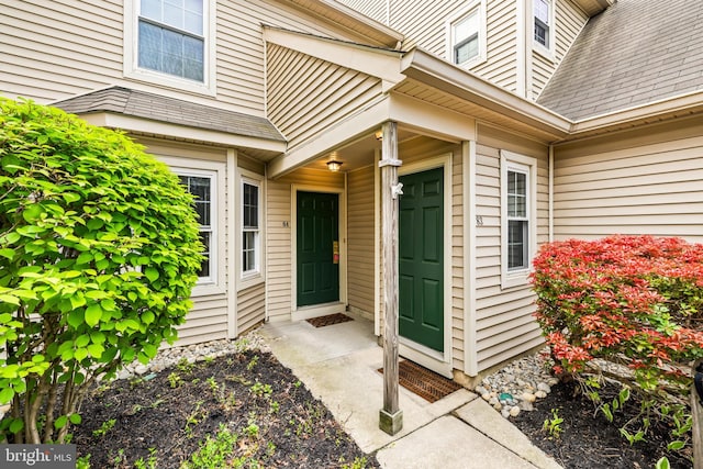 property entrance featuring roof with shingles