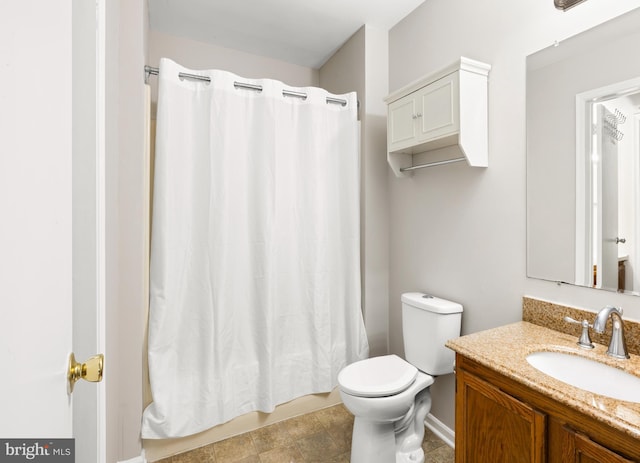 bathroom featuring baseboards, vanity, and toilet