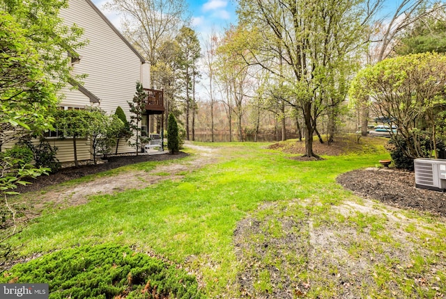 view of yard featuring a balcony and central AC unit