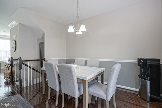 dining room with baseboards, an inviting chandelier, and wood finished floors