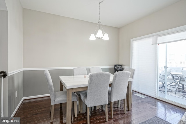 dining space featuring baseboards, dark wood-style flooring, and a chandelier