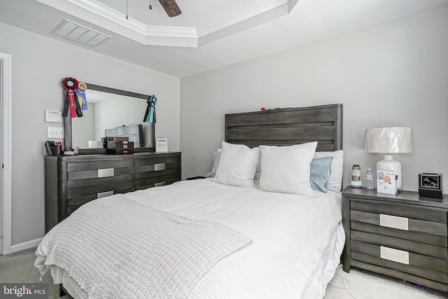 bedroom with visible vents, baseboards, carpet, a tray ceiling, and a ceiling fan