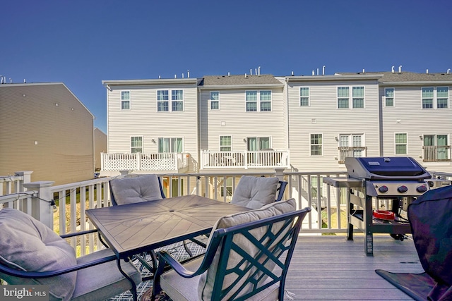 wooden terrace with outdoor dining space and grilling area