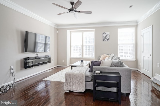 living area featuring crown molding, a healthy amount of sunlight, dark wood-style flooring, and baseboards