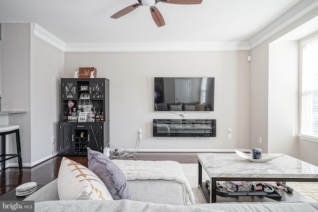 living area featuring dark wood-type flooring, a healthy amount of sunlight, and ornamental molding