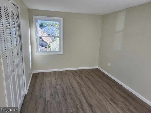 unfurnished bedroom with a closet, baseboards, and wood finished floors