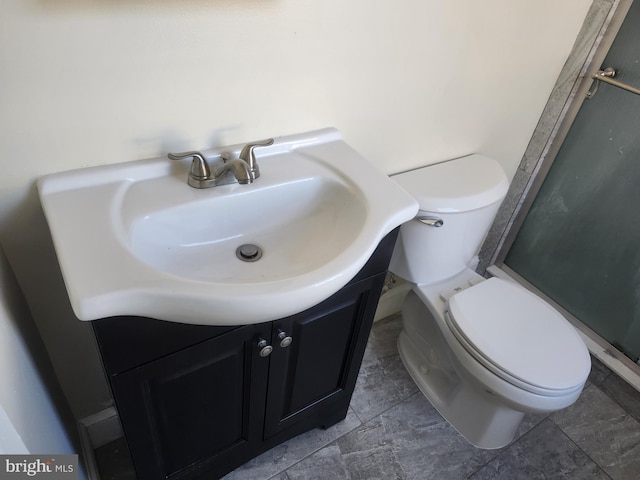 bathroom featuring toilet, an enclosed shower, and vanity