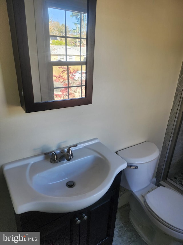 bathroom featuring plenty of natural light, vanity, and toilet