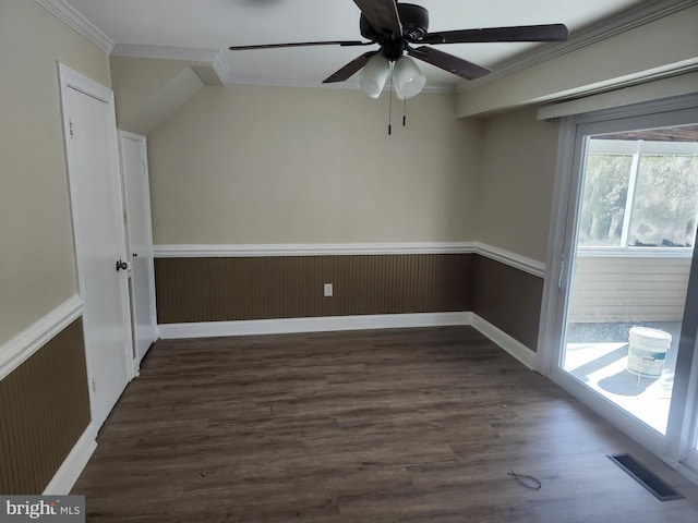 spare room featuring visible vents, wainscoting, dark wood-style floors, ceiling fan, and crown molding