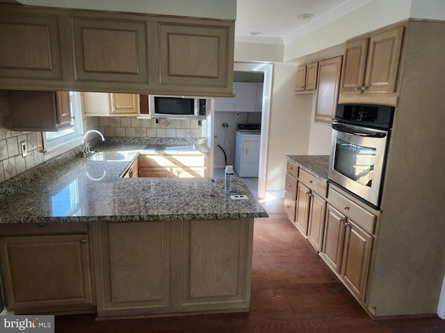 kitchen featuring stone counters, stainless steel appliances, a sink, washer / dryer, and crown molding