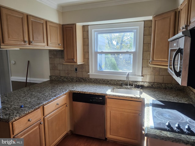 kitchen featuring decorative backsplash, ornamental molding, dark stone countertops, stainless steel appliances, and a sink