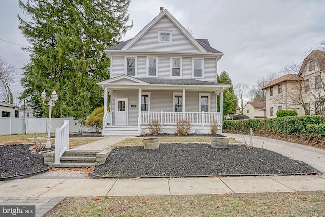 view of front of house featuring fence and covered porch