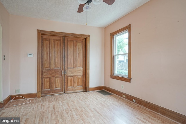 unfurnished bedroom featuring baseboards, wood finished floors, visible vents, and a textured ceiling