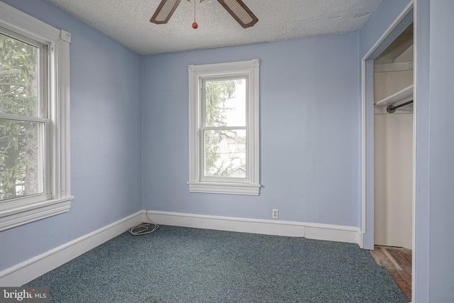 unfurnished bedroom with carpet flooring, ceiling fan, a textured ceiling, and baseboards