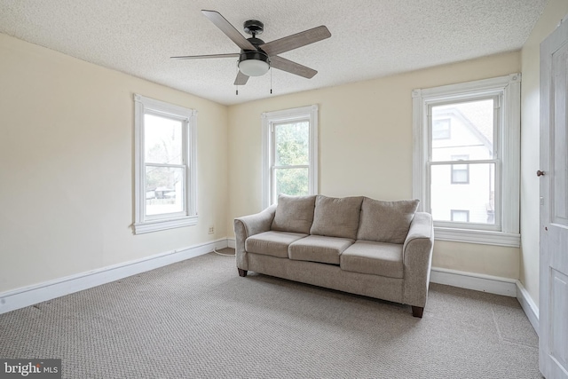 interior space with ceiling fan, a textured ceiling, and baseboards