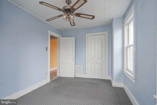 unfurnished bedroom with visible vents, baseboards, carpet, and a ceiling fan