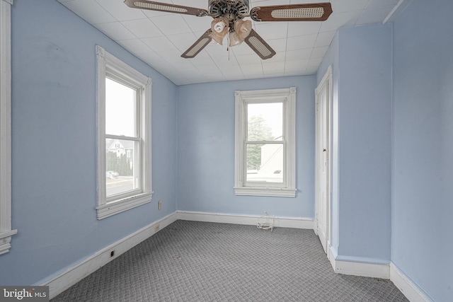 carpeted empty room with baseboards and ceiling fan