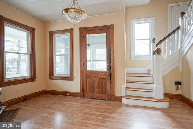 foyer featuring stairway, light wood-style flooring, and a wealth of natural light