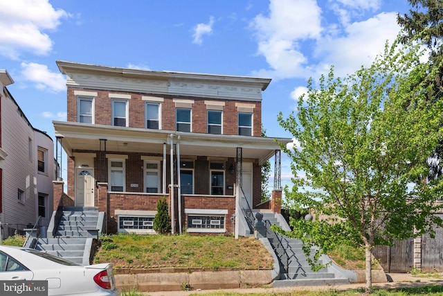 view of front facade featuring brick siding and covered porch