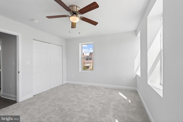 unfurnished bedroom with a closet, baseboards, ceiling fan, and carpet flooring