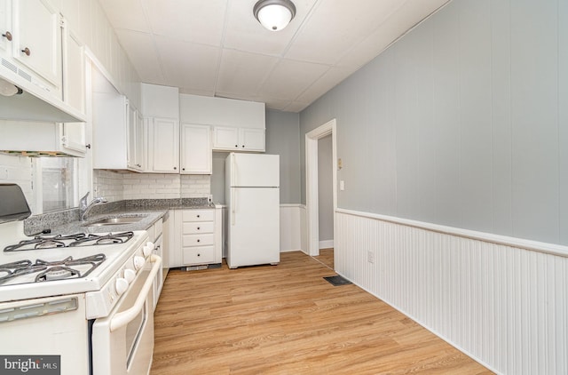 kitchen featuring light wood-style floors, white appliances, white cabinets, and a sink