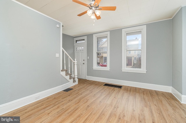 entryway featuring light wood finished floors, stairway, visible vents, and crown molding