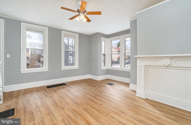 unfurnished living room with ornamental molding, a healthy amount of sunlight, and visible vents