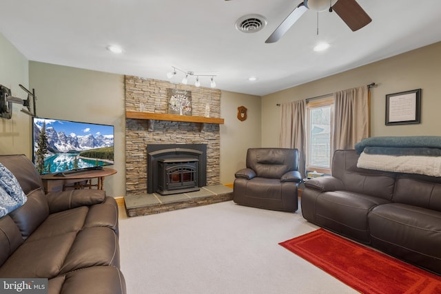 carpeted living area featuring visible vents, a wood stove, a ceiling fan, and recessed lighting