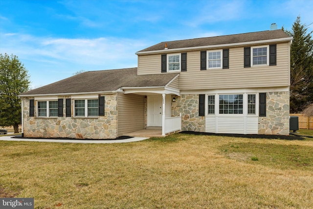 colonial inspired home with a shingled roof, cooling unit, stone siding, and a front lawn