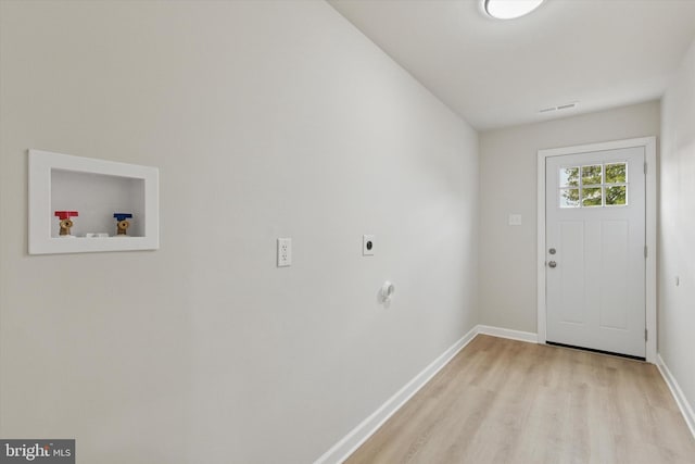 doorway with light wood-type flooring, baseboards, and visible vents