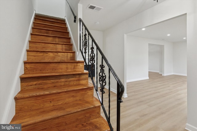 stairs featuring baseboards, visible vents, wood finished floors, and recessed lighting