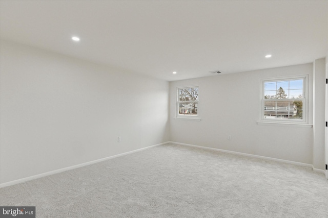 empty room featuring carpet, visible vents, baseboards, and recessed lighting