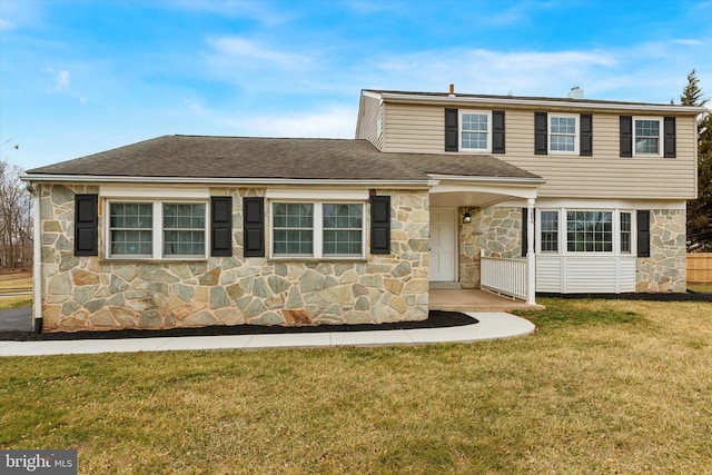 view of front of house with a shingled roof, stone siding, and a front lawn