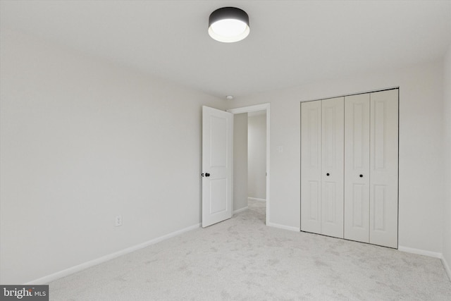 unfurnished bedroom featuring a closet, carpet, and baseboards