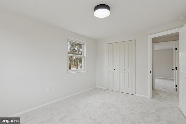 unfurnished bedroom with a closet, carpet flooring, and baseboards