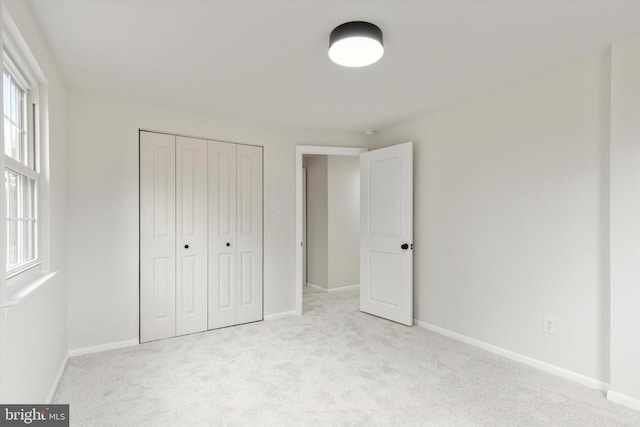 unfurnished bedroom featuring carpet floors, a closet, and baseboards