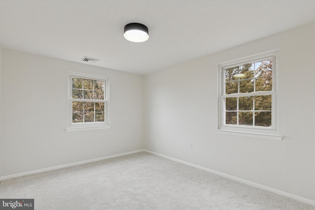 carpeted spare room with baseboards and visible vents