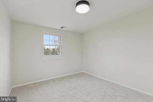 spare room featuring carpet floors, baseboards, and visible vents