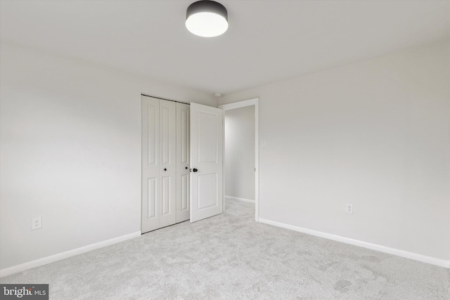 unfurnished bedroom with carpet, baseboards, and a closet