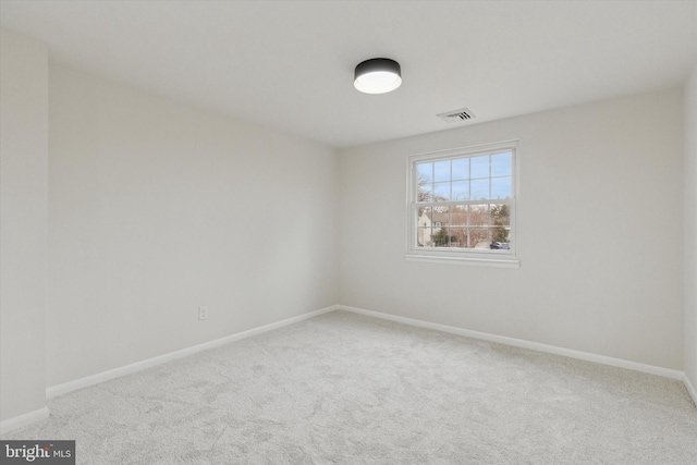 carpeted empty room featuring visible vents and baseboards