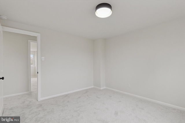 spare room featuring carpet flooring and baseboards