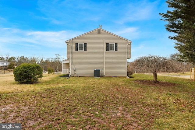 view of side of property with central AC unit and a lawn