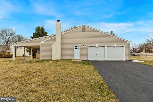 view of front facade featuring a garage, driveway, a chimney, and a front yard