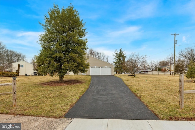 view of front of property with a garage, a front yard, and fence