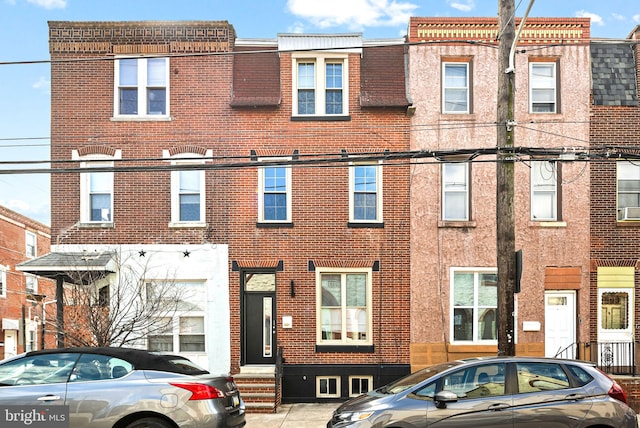 townhome / multi-family property featuring entry steps and brick siding