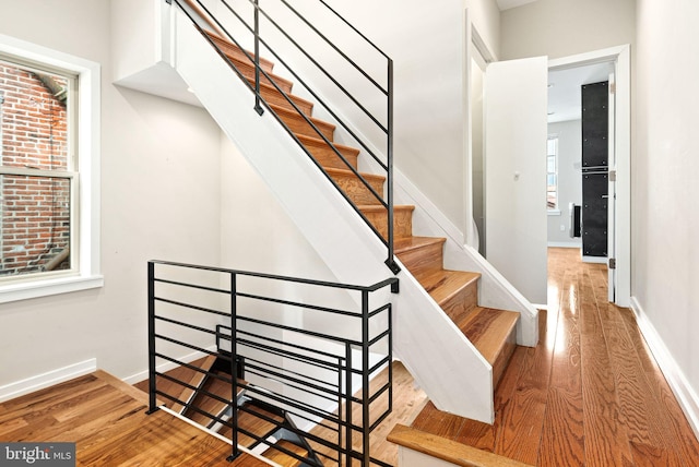 stairway with wood-type flooring and baseboards