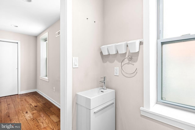 bathroom featuring visible vents, vanity, baseboards, and wood finished floors