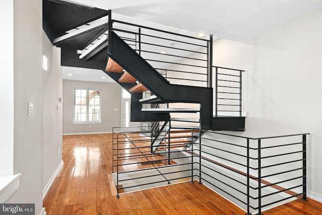 staircase with hardwood / wood-style flooring and baseboards